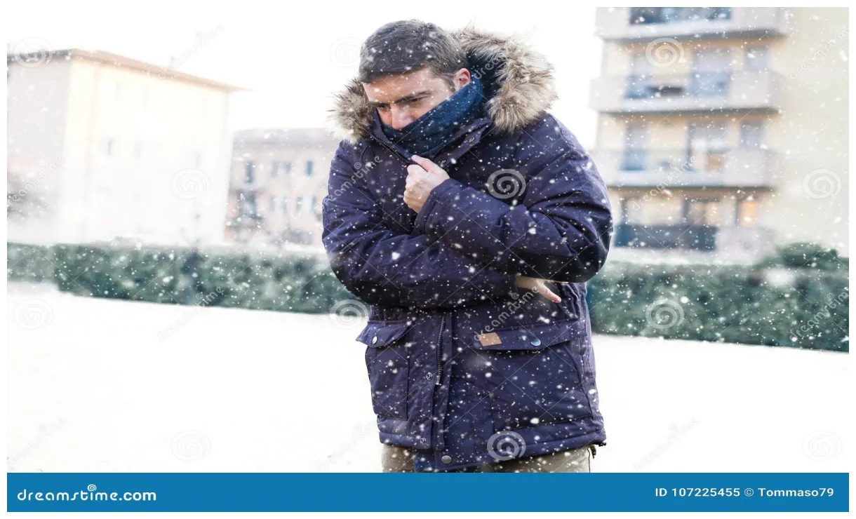 Portrait of man feeling very cold under snowy weather stock