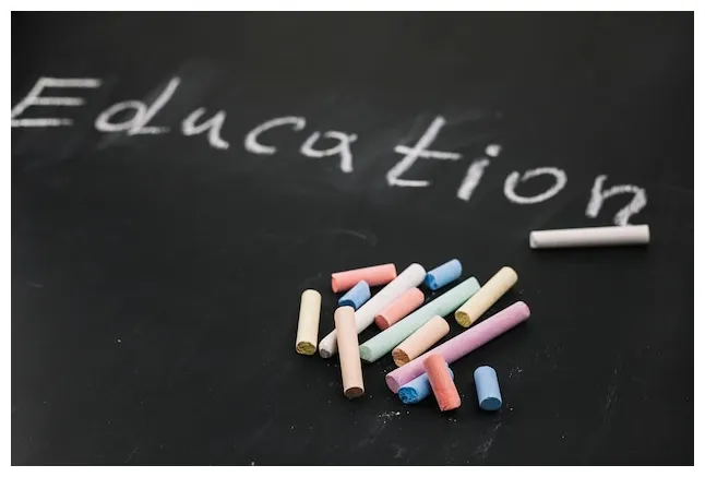 Free teacher pointing finger to board